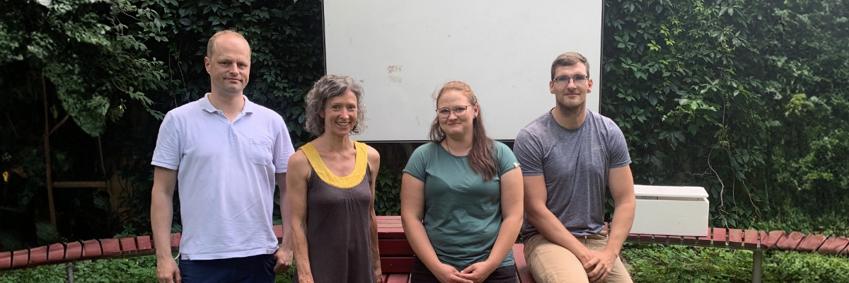 Im Grünen Klassenzimmer sitzen und stehen Dirk Wohlrabe und Nadine Matthes von der TU Dresden als Betreuende gemeinsam mit den Studierenden zur Schulassistenz in Qualifizierung Diana Heimann und Felix Fuchs. Die Personen sind von links nach rechts aufgezählt.