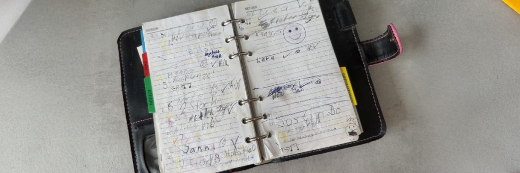 Ein Filofax liegt aufgeschlagen auf einem Tisch. Er war das so genannte Klassenbuch von Lara Schreck als Kind.